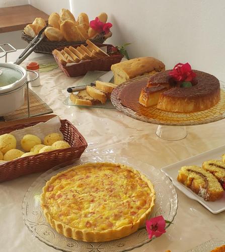 a table with pies and pastries and bread on it at Pousada Varanda do Sol in Arraial d'Ajuda