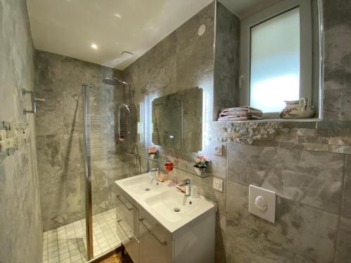a bathroom with a sink and a shower at DDay Aviators Le Manoir in Arromanches-les-Bains