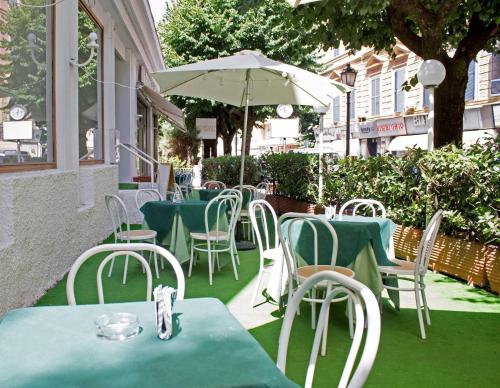 a group of tables and chairs with an umbrella at Hotel Imperiale & Spa in Fiuggi