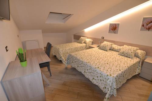 a hotel room with two beds and a table at B&B Canavaccio in Urbino