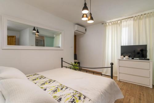 a bedroom with a bed and a mirror and a tv at Villa Alba in Livade