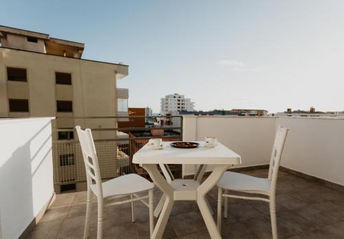 a white table and chairs on a balcony at Hotel Miki in Durrës