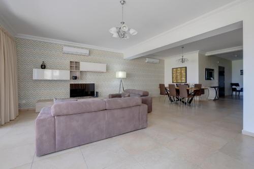a living room with a couch and a dining room at SEAFRONT LUX APART inc POOL, Upmarket Area in Sliema