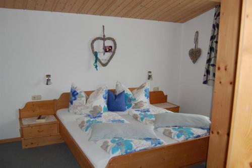 uma cama com lençóis e almofadas azuis e brancos em Haus Schreieck Klaudia em Höfen