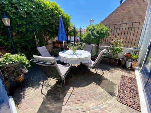 a patio with a table and chairs and an umbrella at The New Fisherman’s House in Zandvoort