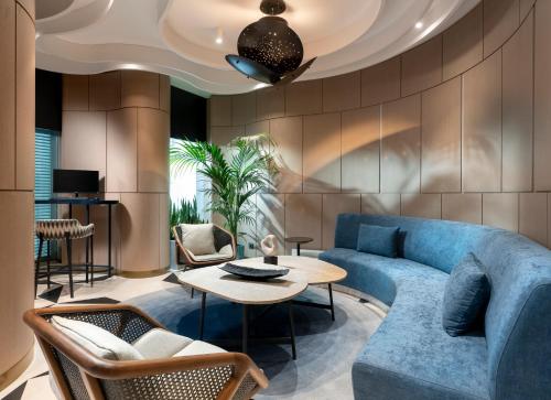 a living room with a blue couch and a table at Radisson Collection Hotel, Bodrum in Akyarlar