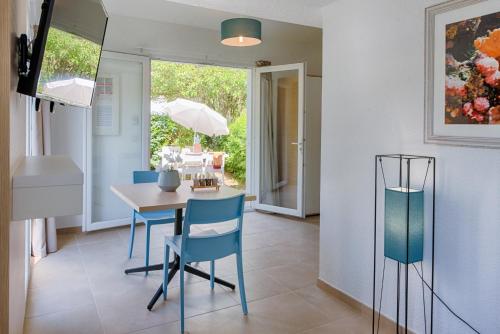 a dining room with a table and blue chairs at Comfort Aparthotel Mandelieu la Napoule Village in Mandelieu-la-Napoule