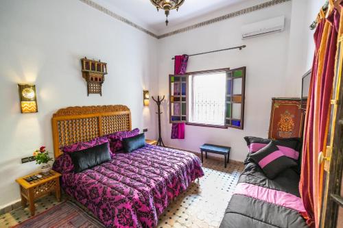 a bedroom with a bed and a couch at Riad Jardin Chrifa in Fès