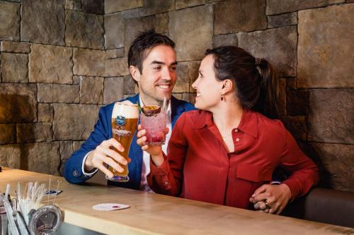 a man and a woman sitting at a table with drinks at Hotel Gasthof Ochsen in Kißlegg