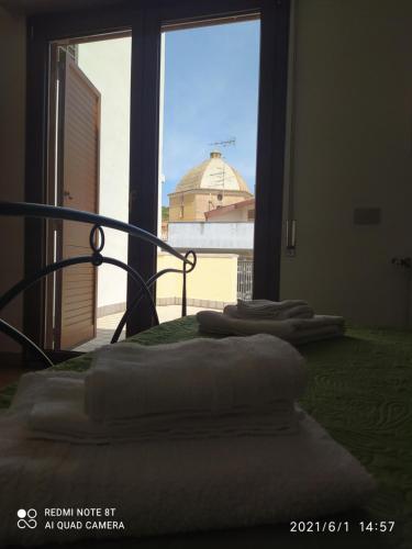 a room with a bed with a view of a building at Affitti Brevi Mamoiada Centro in Mamoiada