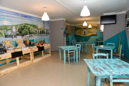 a restaurant with tables and chairs and a mural on the wall at Ostello Verbania in Verbania