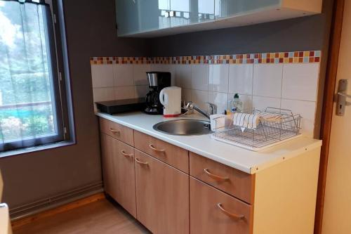 une cuisine avec un évier et un plan de travail dans l'établissement Le Longchamp, à Honfleur