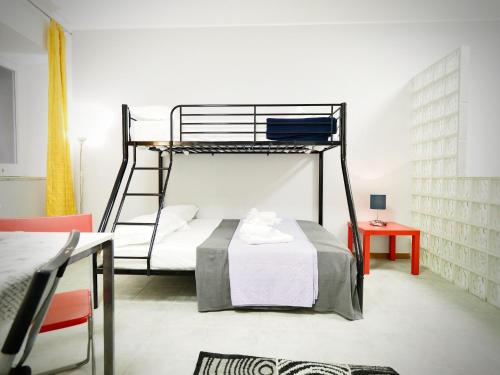 a bedroom with a bunk bed and a table at DIMORA SOTTORIPA DI FRONTE ALL ACQUARIO - GENOVABNB it in Genoa