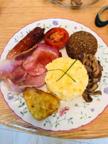um prato de pequeno-almoço com ovos, bacon e outros alimentos em Petra House B&B em Galway