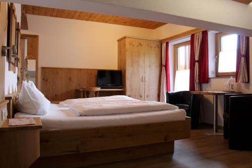 a bedroom with a bed and a tv in it at Gästehaus Baltram in Ramsau