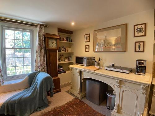 a home office with a desk and a fireplace at HORTUS HOUSE - Regency style apartment with attached parking in Brixham