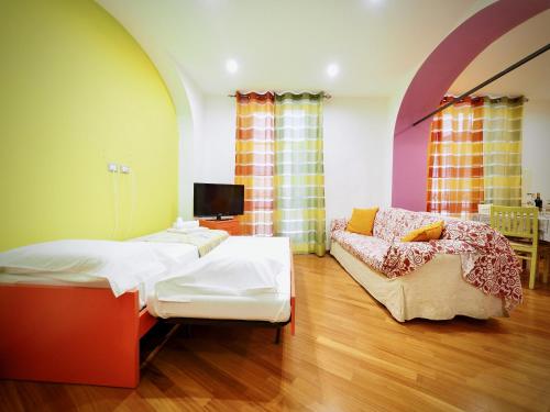 um quarto com uma cama e um sofá em DIMORA DEL MOLO ACQUARIO - GENOVABNB it em Génova