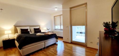 a bedroom with a bed and a large window at VIP Apartamenty Stara Polana in Zakopane