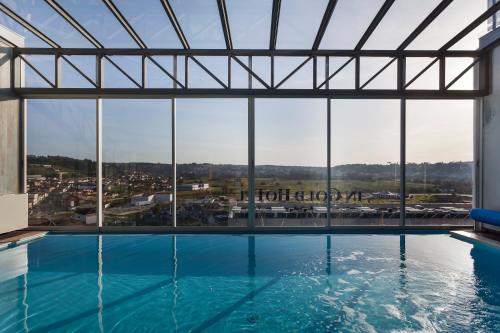 a large swimming pool with a view of a city at In Gold Hotel & Spa in Águeda