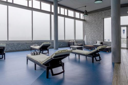 a waiting room with couches and tables and windows at In Gold Hotel & Spa in Águeda