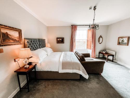 a bedroom with a bed and a couch and a window at Forss House in Thurso