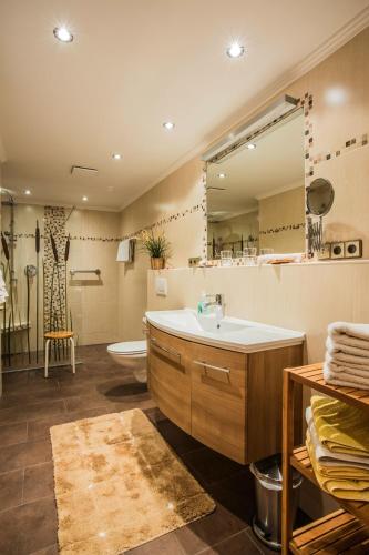 a bathroom with a tub and a sink and a mirror at Ferienwohnungen Fendt in Bischofswiesen