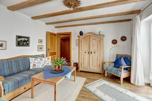 a living room with a blue couch and a table at Ferienwohnungen Fendt in Bischofswiesen