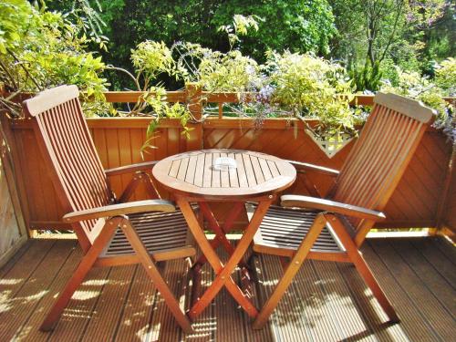 two chairs and a table on a deck at Ostsee Hotel-Pension An der Lindenallee in Bad Doberan