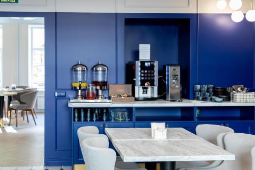 a kitchen with blue walls and a table with chairs at Atlantic Hotel in Saint Petersburg