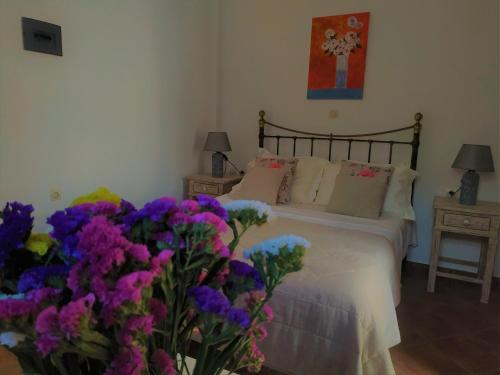 a bedroom with a bed with purple and purple flowers at My Little Suites in Ermoupoli