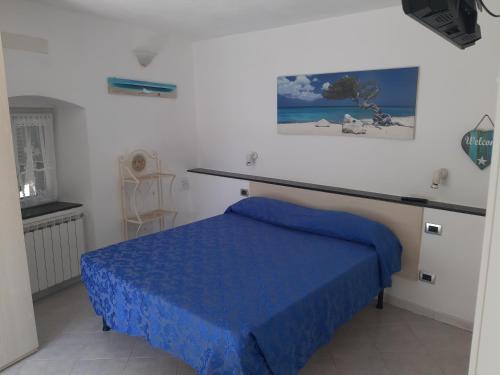 een kamer met een bed met een blauwe deken erop bij Appartamento Il giardino in Levanto