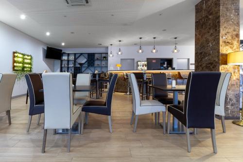 a dining room with chairs, tables, and chairs at In Gold Hotel & Spa in Águeda