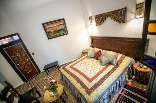 a small bedroom with a bed and a table at Riad Jardin Chrifa in Fès