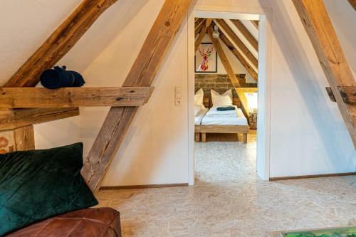 a attic room with a bed and a mirror at Schlafstaelle in Geusfeld