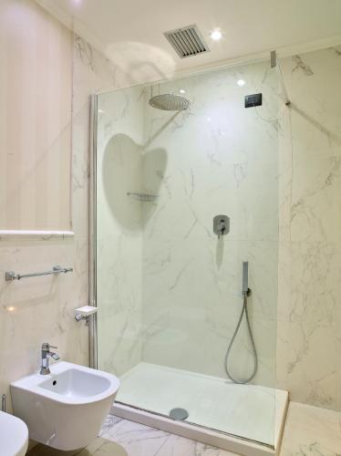 a bathroom with a shower and a toilet and a sink at Hotel Niccolo' V - Terme dei Papi in Viterbo