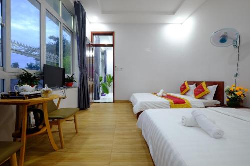 頭頓的住宿－Shiny Villa Vung Tau，酒店客房设有两张床、一张桌子和一台电脑。