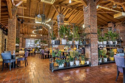 a restaurant with tables and chairs and potted plants at Ribarski konaci in Doboj