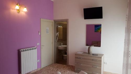 a bathroom with purple walls and a sink at La Fenice Salentina in Alezio