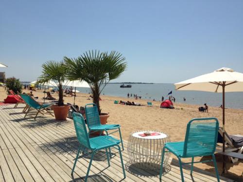 - un groupe de chaises et un parasol sur une plage dans l'établissement studio presqu'île Fouras proche de la plage parking privé, à Fouras