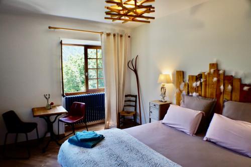 - une chambre avec un grand lit et une fenêtre dans l'établissement Château du Vigny - Maison d'hôtes, à Saint-Michel-de-Maurienne