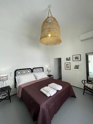 a bedroom with a large bed and a chandelier at Le Casuzze Ammare in Favignana
