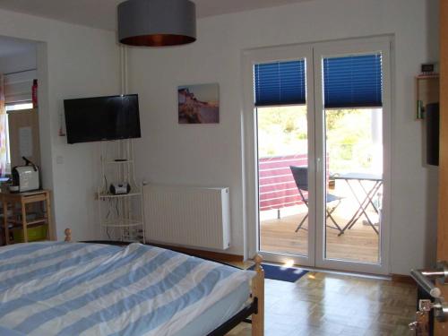 a bedroom with a bed and a sliding glass door at Ferienwohnung Gaby in Marburg an der Lahn