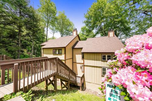 a house with a staircase and flowers in front of it at The Hemlock Hideaway in Sugar Mountain