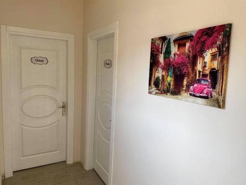 a painting of a car on a wall next to a door at Cilek Butik Hotel in Cesme