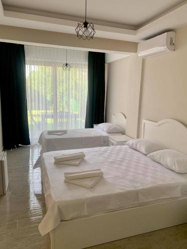 a bedroom with two beds and a large window at Cilek Butik Hotel in Cesme