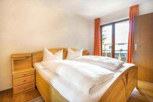 オーベルストドルフにあるFerienwohnung Bockwoldtのベッドルーム1室(白いシーツ付きのベッド1台、窓付)