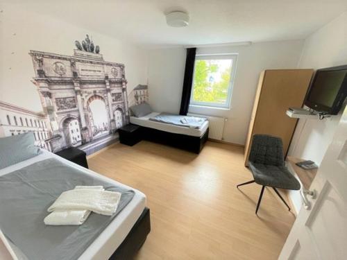 a bedroom with a bed and a chair and a window at Olympia Pension in Dachau