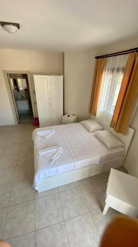 a bedroom with a large white bed and a window at Cilek Butik Hotel in Cesme