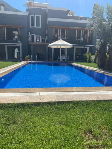 a large blue swimming pool in front of a building at Nur Suites & Hotels in Kalkan