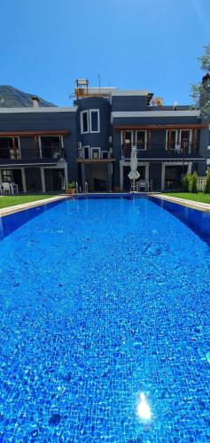 a large blue swimming pool in front of a building at Nur Suites & Hotels in Kalkan